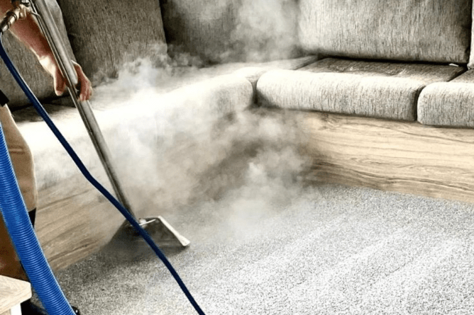 A carpet cleaner powerfully steam cleans the carpets in a static caravan.