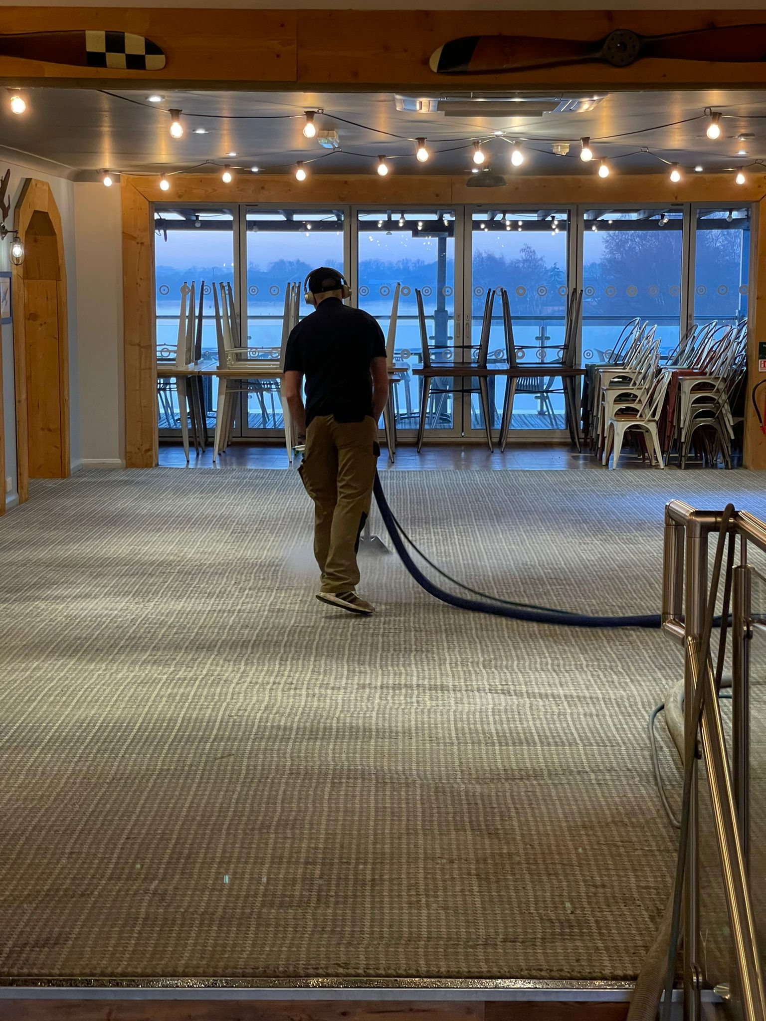 Deep Extraction Carpet Cleaning at Sea A close-up shot of professional commercial equipment deep-cleaning a high-use carpet in the dining area of a cruise ship