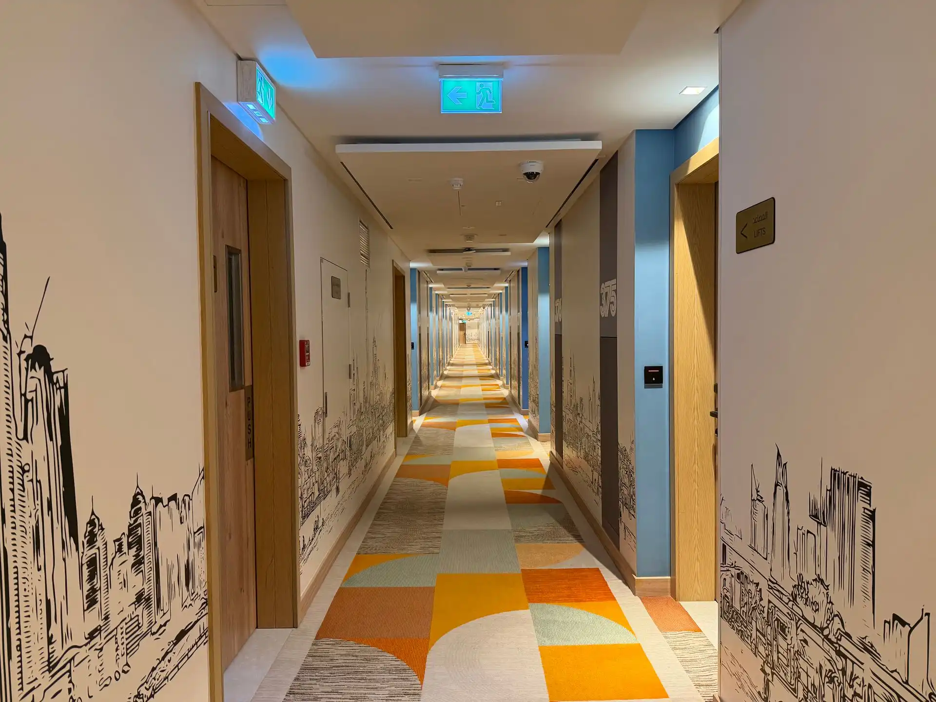 A wide view down a secondary school corridor with heavily restored carpets showing pile alignment lines.
